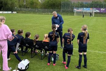 Trainer spricht mit Kinder-Fußballteam am Spielfeldrand